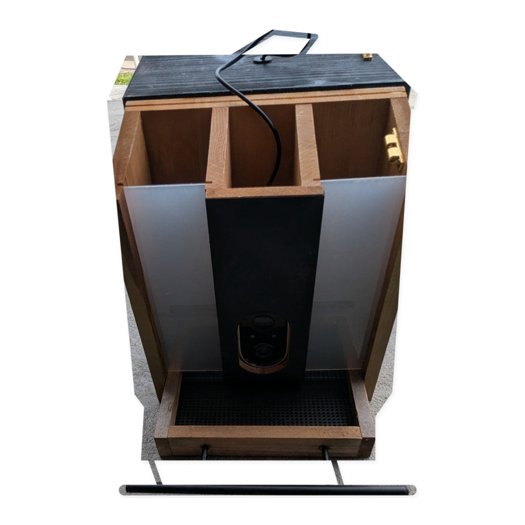 Front view of the actual Evergreen smart bird feeder with open seed compartments on studio white